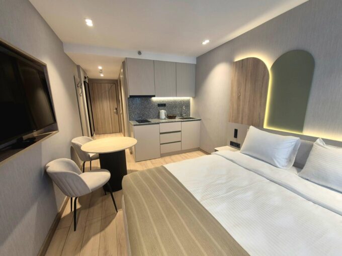 Общая зона студии Marina Club в Батуми с кухней, кроватью, столом и телевизором
